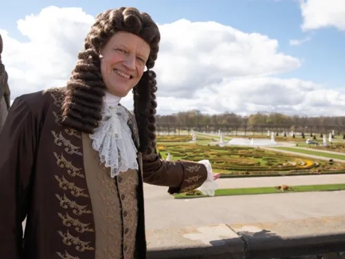 Mann mit Per&uuml;cke in Kleidung aus der Barockzeit in einem Barockgarten